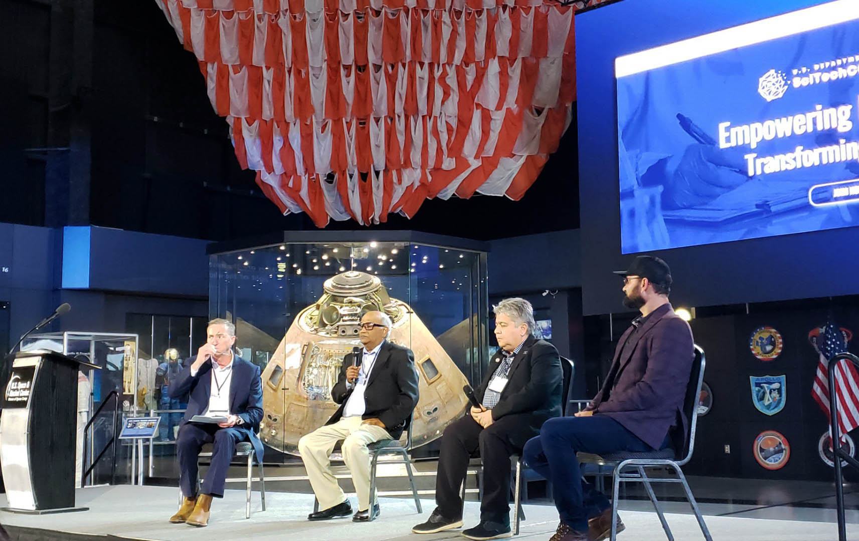 Jason Preisser, Dr. Rami Mommareddi, Dr. Satilmis Budak and Christopher Udall seated on stage addressing crowd