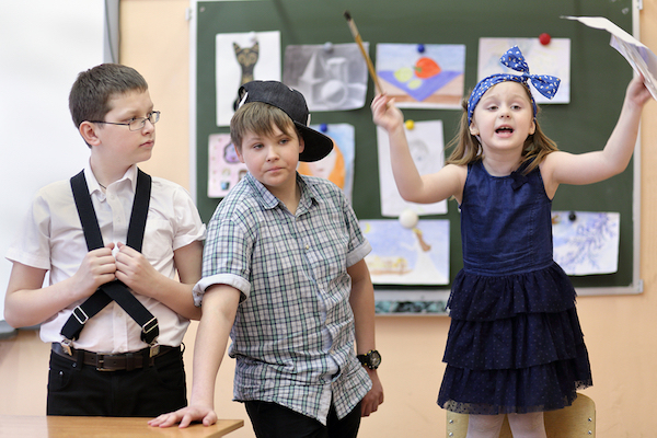 three students: two boys and one girl act out scene in class performance at drawing lesson | MiddleWeb